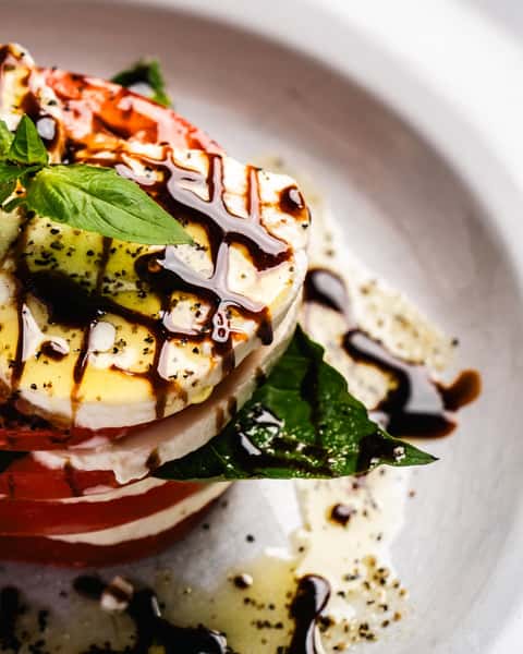 fresh tomato paired with creamy mozzarella, fragrant basil leaves, and a drizzle of extra virgin olive oil