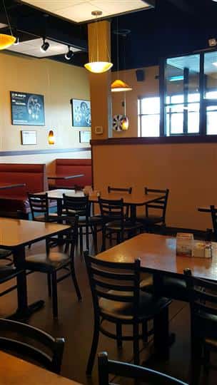 Tables and chairs with orange walls and pictures