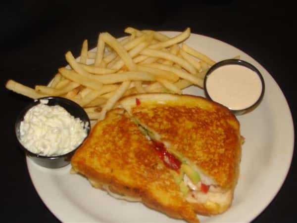 Sandwich grilled with side of fries and sauces