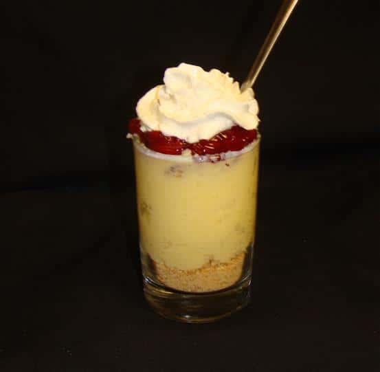 Dessert topped with whipped cream and strawberries in a glass