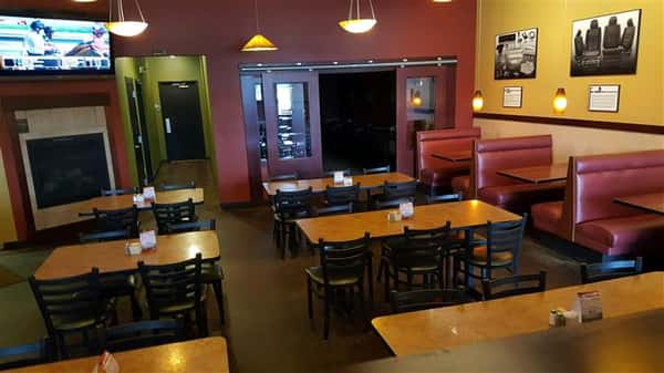 tables and chairs with red walls and pictures on the wall