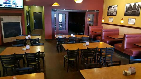 Tables and chairs with orange walls and pictures