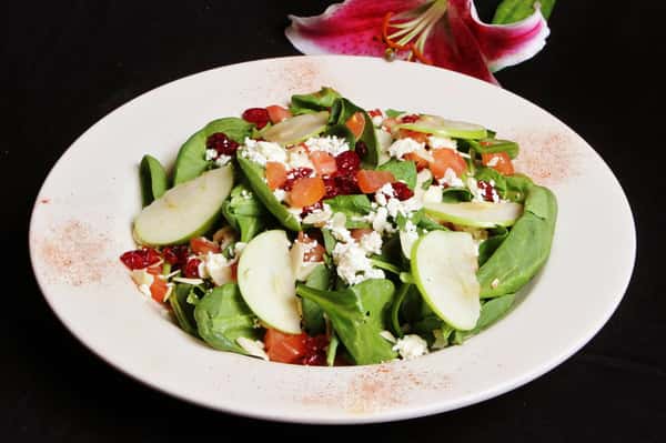 Mixed green salad with dried cranberries, feta cheese and sliced apples