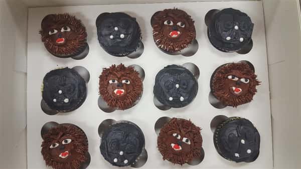 Frosted cup cakes resembling wookie and Darth Vader from star wars