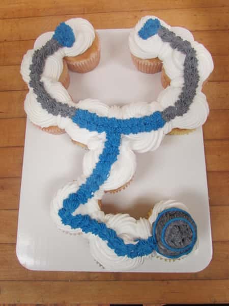 Frosted cup cakes lined up to resemble a blue and grey stethoscope