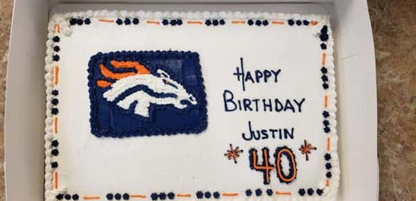 Blue and Orange decorated rectangle cake that says Happy Birthday Justin