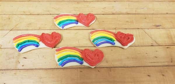 Cookies decorated and shaped like hearts with rainbows