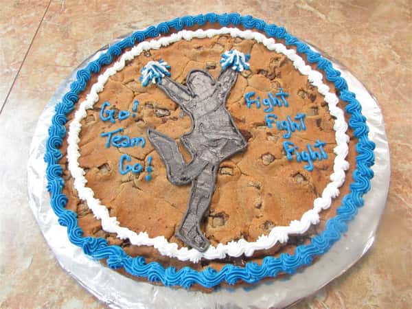 Circular cookie cake that says "go Team Go" and "Fight Fight Fight" on it with a silhouette of a cheerleader in the center