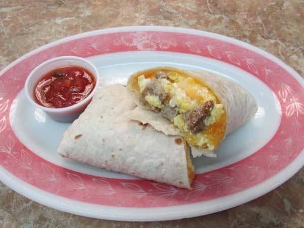 Breakfast burrito stuffed with scrambled eggs, cheese and sausage with a side of salsa
