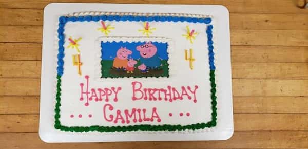 Rectangle cookie that sayas Happy Birthday Camila decorated with cartoon pig characters in the center