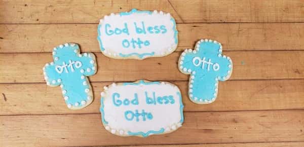 Four cookies in the shape of crosses and squares that say god bless otto