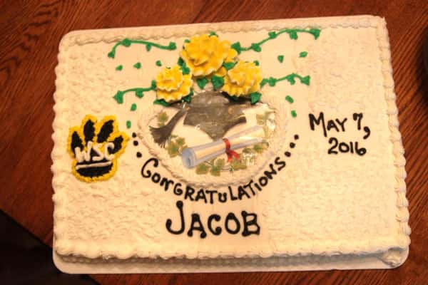 White frosted cake cake that reads congratulations Jacob May 7th 2016" decoarted with a paw that reads "WSC" and a picture of a diploma in the middle