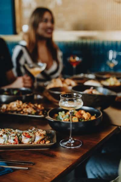 dishes and drinks on a table with people in background