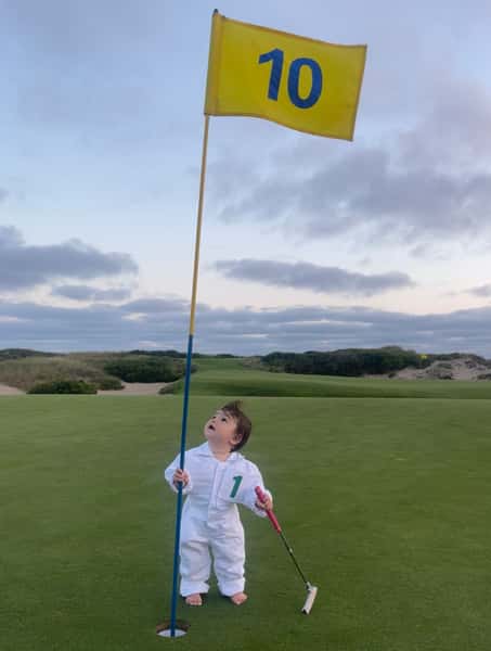 golf field and a child in the middle of the phto