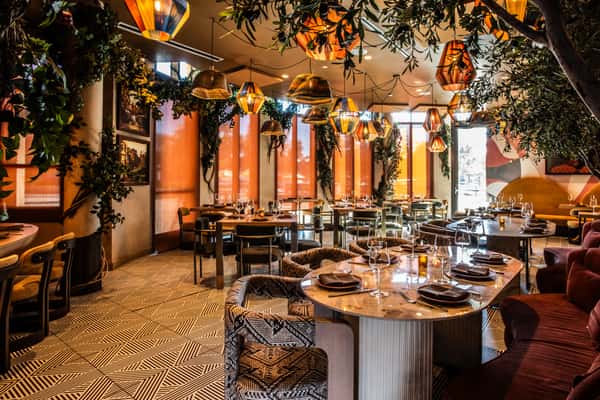 Stylish upscale restaurant interior with patterned flooring, marble tables, and warm decorative lighting