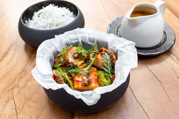 Spicy shrimp dish with jalapeños and herbs served alongside steamed rice and savory sauce