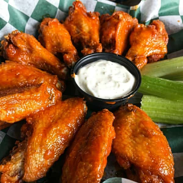 Crispy buffalo chicken wings coated in sauce, served with celery sticks and ranch dressing.