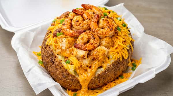 Loaded baked potato topped with seasoned shrimp and cheese at DSquared in St. Louis