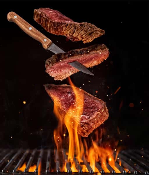 steak over grill flames