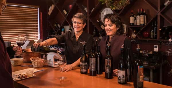 Owners Deb Payne and Anna Marie Dos Remedios pour Idle Hour's wines in the winery.