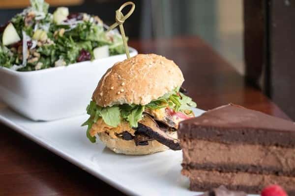 a side salad, a slider, and a piece of chocolate cake on a plate