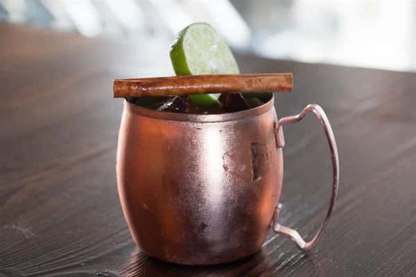 an alcoholic drink in a copper mug sitting on the bar