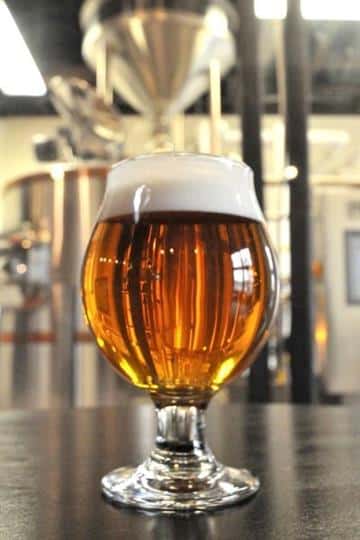 a glass of beer sitting on the bar