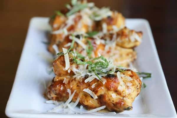 wings with cheese on top on a plate