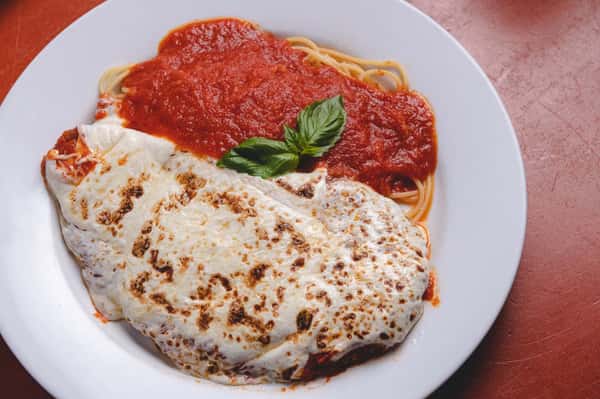 Classic Italian pasta topped with rich tomato marinara sauce, melted cheese, and fresh basil, served at Pasta Lovers Trattoria in Times Square, NYC.