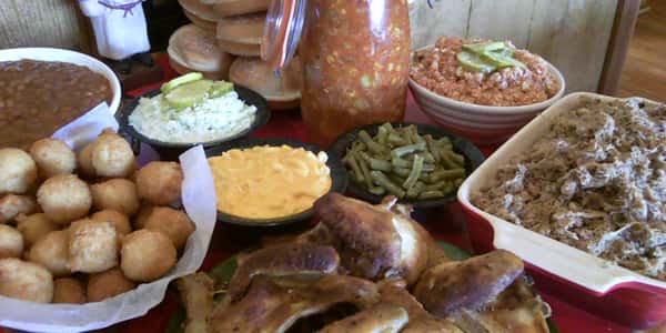 catering food displaying green beans, chicken, hush puppies and rolls
