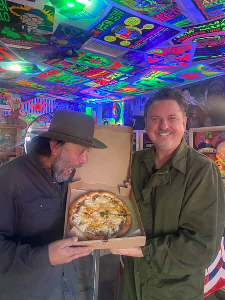 Men holding box of pizza