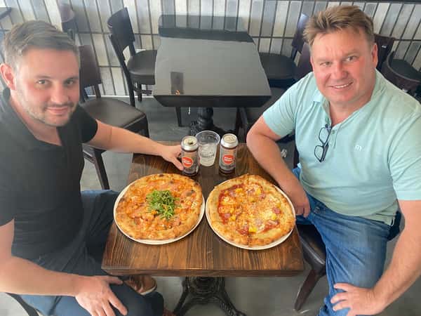 Men sharing pizzas