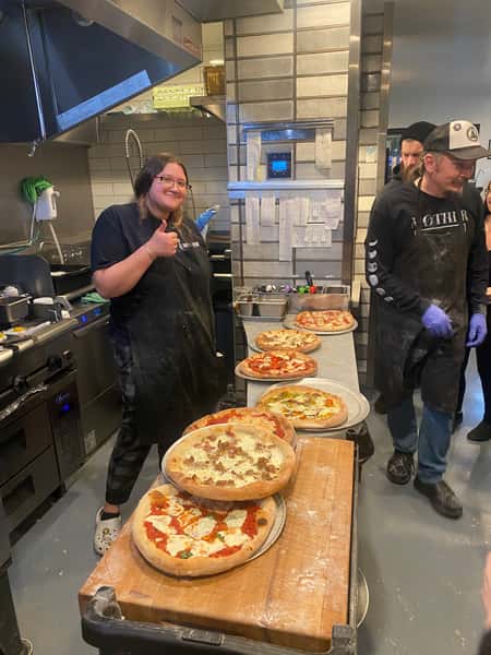 Pizzas made with chefs posing
