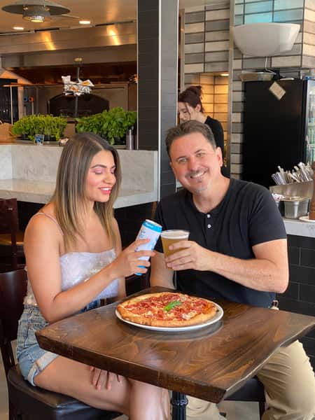 Man and woman sharing pizza and drink