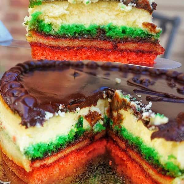 a rainbow cookie cake with a slice missing