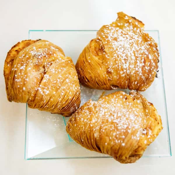 Three croissants covered in powdered sugar
