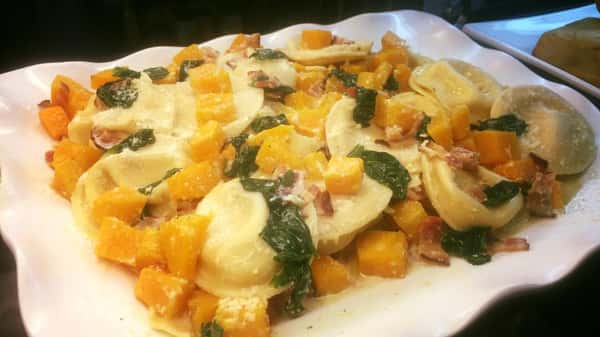 Tray of cheese ravioli tossed with spinach, prosciutto, and butternut squash.