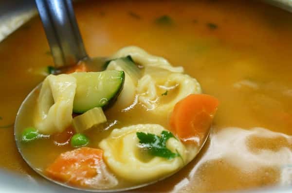 Tortellini soup with mixed vegetables in a pot.