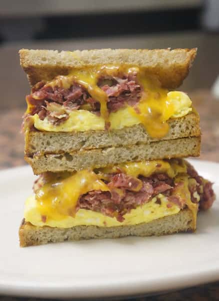 1egg sandwich with corned beef and cheese on wheat bread