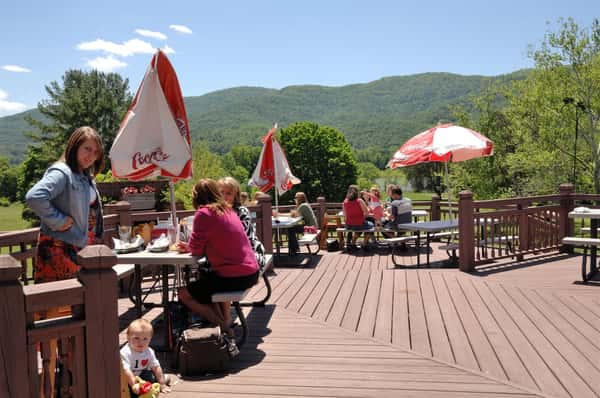 outside deck area with tables and umbrellas and a few people