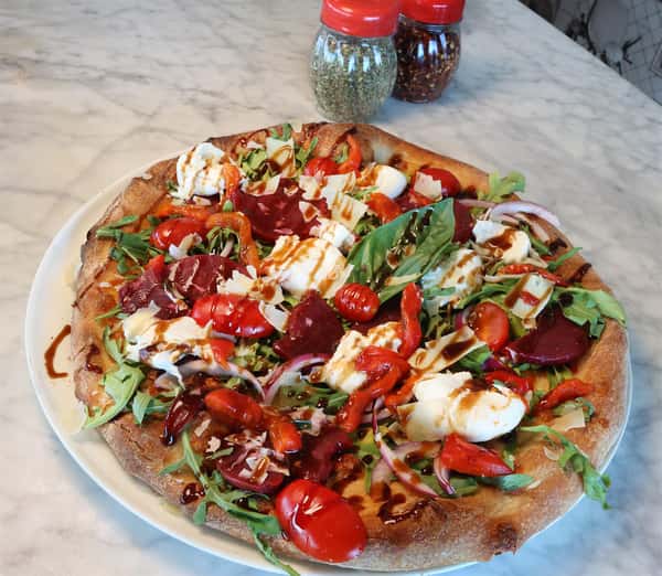 pizza with arugula, tomatoes, mozzarella, beets, and a balsamic drizzle