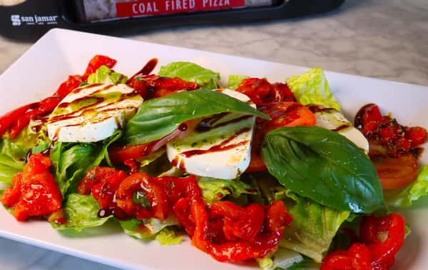 iceberg lettuce with roasted red peppers, sliced mozzarella and tomatoes with a balsamic drizzle