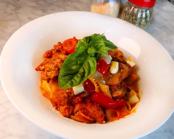 Pappardelle Alla Siciliana with Fresh Pappardelle Pasta with Cherry Tomatoes, Assorted Mushrooms, Eggplant and Italian Sausage topped with Homemade Melted Mozzarella