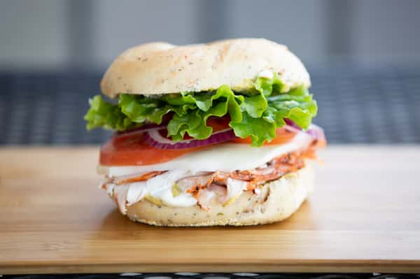 bagel sandwich with smoked salmon, lettuce, tomato, and cream cheese on a toasted bagel