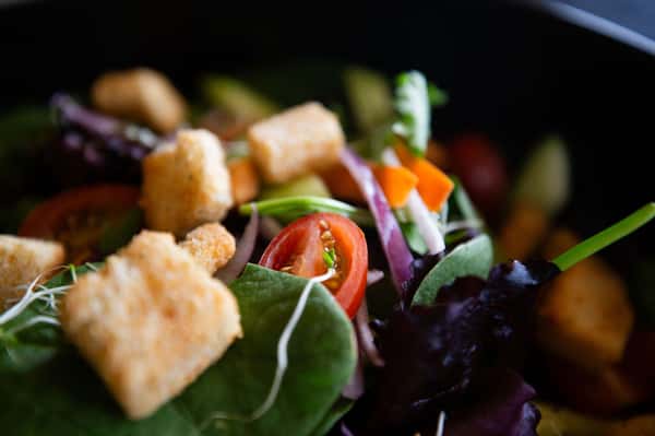fresh garden salad with leafy greens, tomatoes, and croutons in close-up