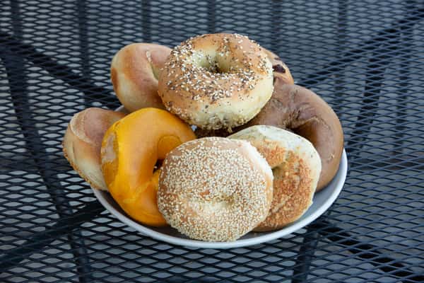 assorted fresh bagels including plain, sesame, and everything bagels in a basket