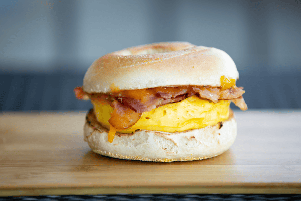 egg, bacon, and melted cheese breakfast sandwich on a toasted bagel