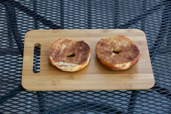 cinnamon raisin bagels sliced and toasted on a wooden board