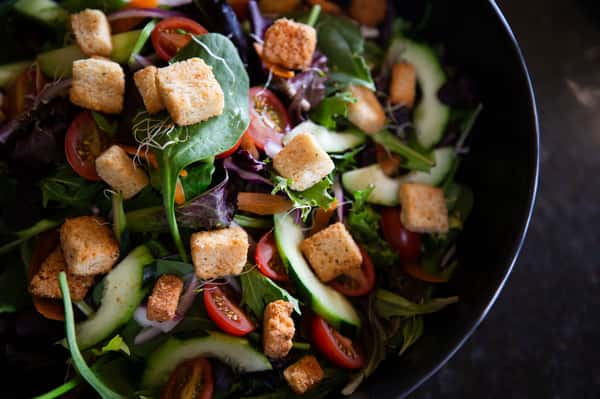 fresh salad with mixed greens, tomatoes, cucumbers, croutons, and shaved parmesan