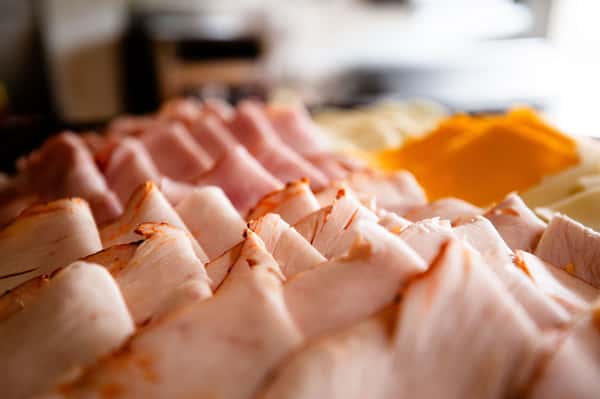 thinly sliced deli meat arranged in neat rows on a serving platter